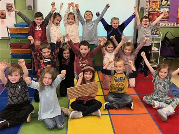 Students holding golden keyboard